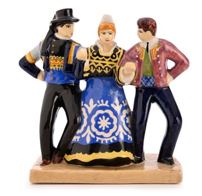 trois figurines représentant un homme et une femme, posées sur un socle en bois