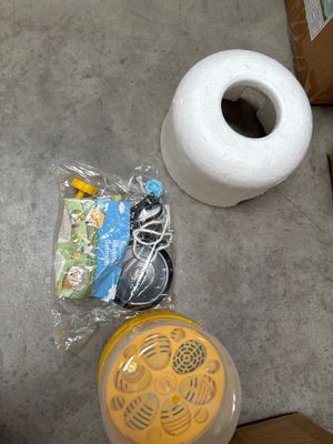 a roll of toilet paper and some other items on the floor