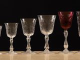 several empty wine glasses lined up on a table with a black background