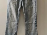 un pantalon en jean suspendu à un cintre devant un mur blanc