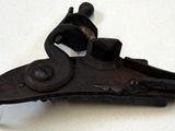 un vieux pistolet posé sur une surface blanche
