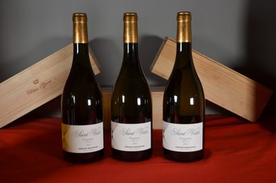 three bottles of wine sit on a red cloth next to a wooden box