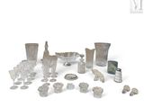 de nombreux objets en argent et en verre posés sur une surface blanche
