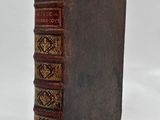 an old book sitting on top of a white surface