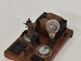 une petite horloge posée sur une table, surmontée d'une ampoule