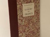 Le livre est posé sur une surface blanche, près d'un mur blanc.