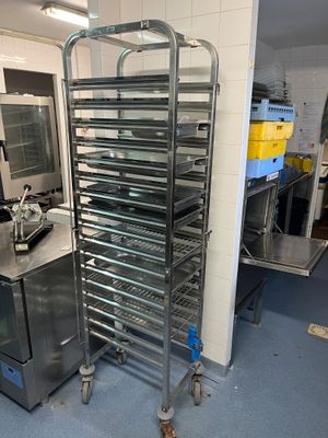 une grande étagère métallique sur laquelle sont posés plusieurs plateaux