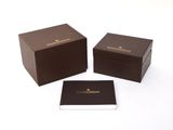 two brown boxes with a card in them sitting on a white surface