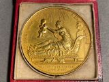 an image of a gold medal in a red case on a table