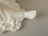 a figurine of a woman sitting on a table
