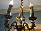 a chandelier with three candles hanging from it ' s ceiling