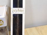 a harry potter wand next to a box of harry potter wands