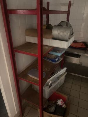 a red shelf in the corner of a room