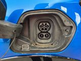 a close up of a blue car with an electric plug in it