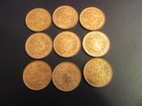 six types différents de pièces d'or sur une surface noire