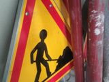 a yellow and red sign with a picture of a man on it
