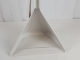 a close up of a white triangle shaped object on a white surface