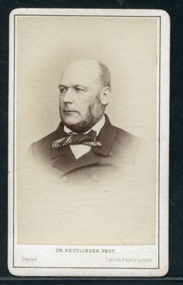 une vieille photo en noir et blanc représentant un homme en costume et nœud papillon