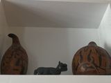 two vases sitting in a white box with a cat figurine