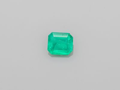 an emerald stone on a white surface