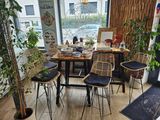 une table avec quatre chaises et une plante dans un coin de la pièce