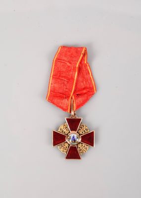 une image représentant une médaille rouge et dorée ornée d'une croix