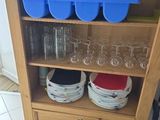 bottles and glasses on a shelf in a kitchen with tile flooring