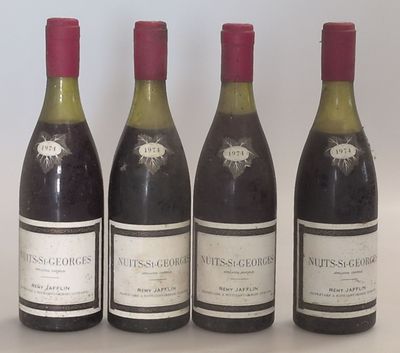 quatre bouteilles de vin sont alignées sur une table