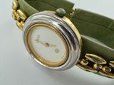a close up of a wrist watch with a chain around it