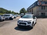 une petite voiture blanche garée devant un bâtiment
