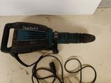 a drill that is laying on the floor next to a cord