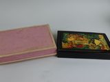 a small box with a painting on it next to a smaller box with a painting on it