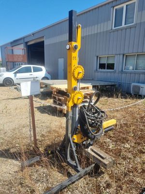 une machine qui est à l'abandon dans la poussière, près d'un bâtiment