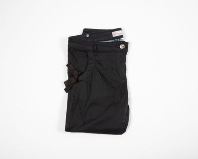 a pair of black pants sitting on top of a white surface