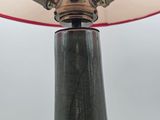 a lamp that is sitting on a table with a red shade
