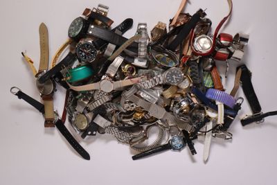 a pile of assorted watches on a white surface