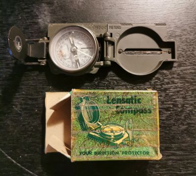 une boîte d'allumettes et un compas posés sur une table