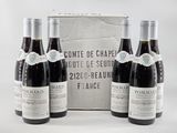 three bottles of wine are sitting in front of a cardboard box