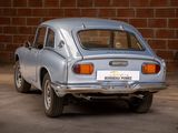 a silver car that is parked in front of a brick wall