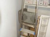 une image représentant une échelle dans une pièce, sur laquelle sont posées des cartons