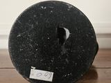 a black object sitting on a wooden floor next to a white wall