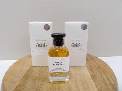deux flacons de vanille en poudre posés sur une table en bois, à côté d'une boîte de vanille en poudre