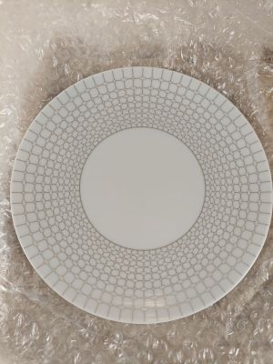 une assiette blanche décorée d'un motif, posée sur une table