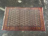 un vieux tapis posé par terre, avec une petite tache de saleté