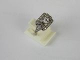 an old cut diamond ring on a white marble stand