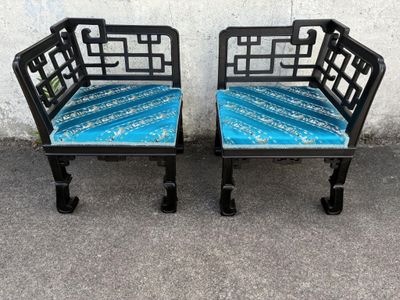 deux bancs noirs recouverts de coussins bleus, placés devant un mur blanc