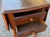 a small wooden table with two drawers on it