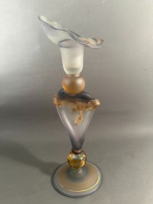un vase en verre surmonté d'un oiseau