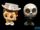 two toy figurines of a skeleton and a man with a top hat