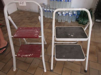 deux tabourets à deux marches placés l'un à côté de l'autre sur un sol carrelé
